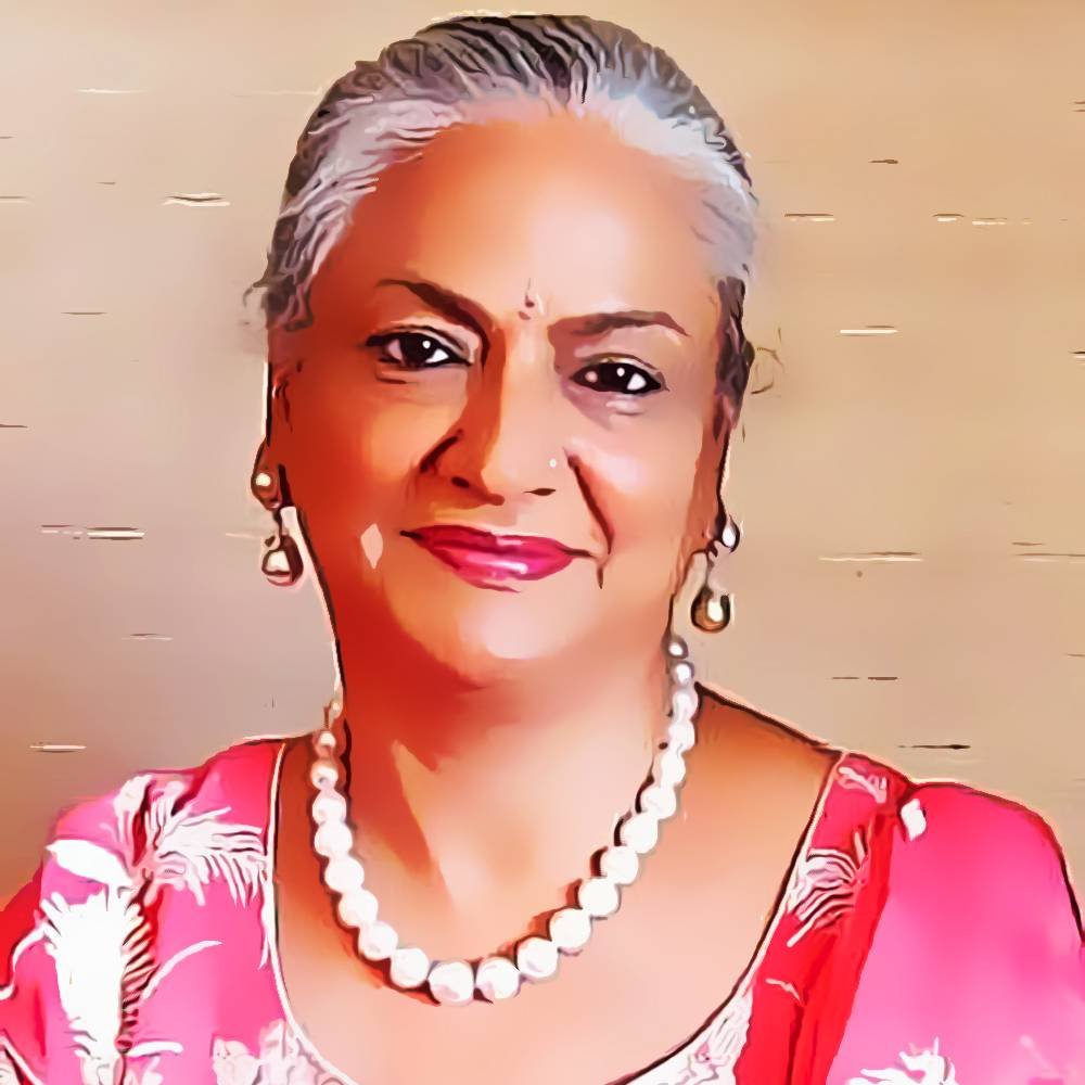 Portrait of an older woman with grey hair, wearing a red floral outfit, pearl necklace, and earrings, smiling at the camera. The image has a subtle artistic filter applied.
